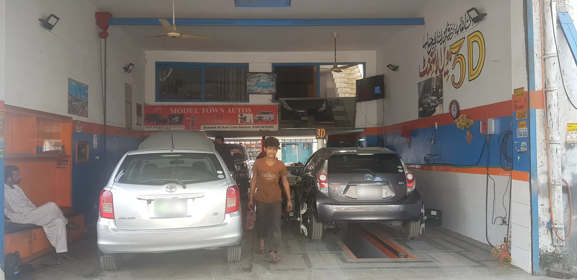 Inside the bay: the Model Town Autos board, the 3D alignment wall and a car on the alignment ramp
