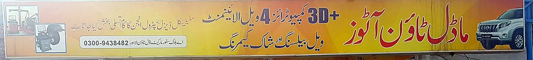 The yellow Model Town Autos signboard, listing 3D+ computerised four-wheel alignment, wheel balancing, shock cambering, and petrol and diesel engine work, with the number 0300-9438482